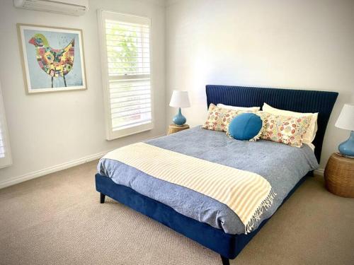 ein Schlafzimmer mit einem blauen Bett mit Kissen in der Unterkunft River Front on Hennessy in Tocumwal
