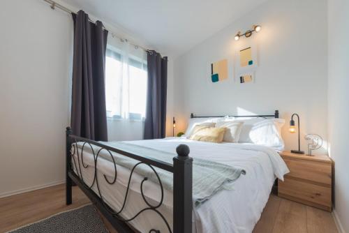 1 dormitorio con 1 cama con sábanas blancas y ventana en Villa Villa Solis - luxury with pool, en Dicmo
