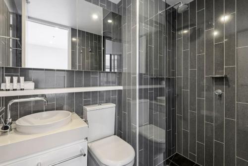 La salle de bains est pourvue de toilettes, d'un lavabo et d'une douche. dans l'établissement 2-Bed Inner-City Pad Bright with Panoramic Views, à Melbourne