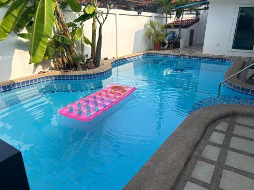 a pool with a pink tray of drinks in it at Nirvana pool villa 2 in Nong Prue