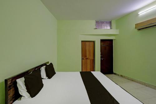 - une chambre avec un lit et une porte en bois dans l'établissement OYO Hotel Shivraj, à Bilāspur