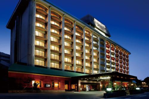 Ooedo Onsen Monogatari Premium Kinugawa Kanko Hotel في نيكو: مبنى الفندق وانارته بالليل