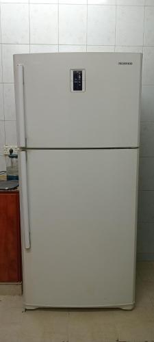 a white refrigerator in a kitchen with its door open at Heritage Hostel Muscat in Muscat