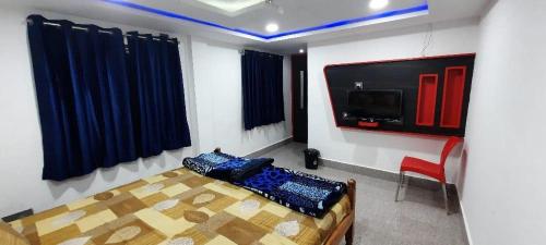 um quarto com uma cama e uma televisão na parede em Hotel Shree Sai em Dāringbārhi