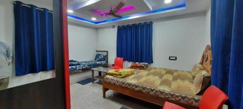 a bedroom with a bed and a ceiling fan at Hotel Shree Sai in Daringbadi