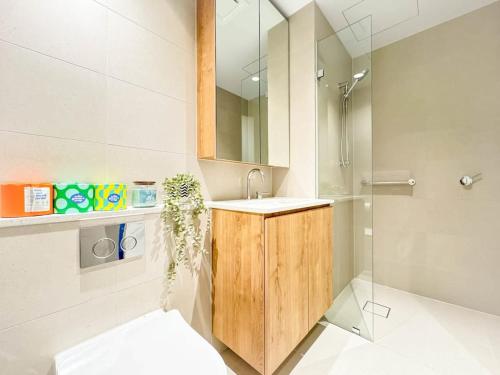 y baño con lavabo, aseo y espejo. en Modern 2B APT BayViews*Pool*GYM en Melbourne