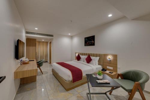 a hotel room with a large bed and a desk at Comfort Inn Sapphire Chandkheda, Ahmedabad in Ahmedabad