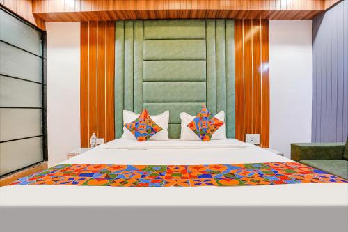 a bedroom with a large white bed with colorful pillows at FabHotel Max in Vadodara