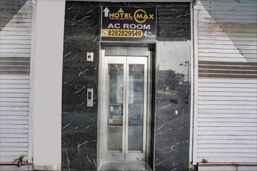 a hotel room entrance with a door and a sign at FabHotel Max in Vadodara