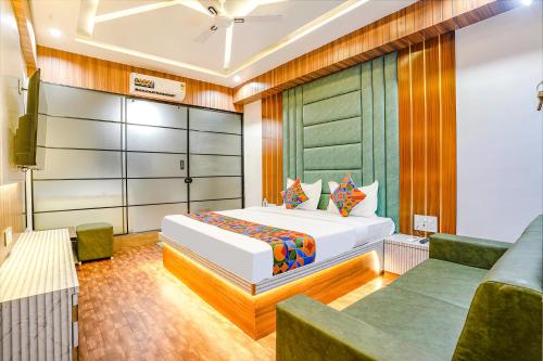 a bedroom with a bed and a couch at FabHotel Max in Vadodara