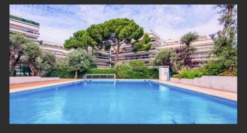 une grande piscine bleue devant un immeuble dans l'établissement ARA 40m2 Classé Immense Terrasse 35 m2 Piscine Antibes Juan Parking, à Antibes
