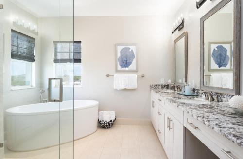 a white bathroom with a tub and two sinks at The Shore House 4br-4,5ba in Key Largo