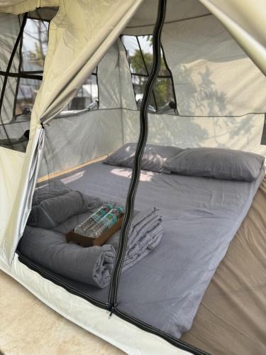 a bed in a tent with a remote control in it at Pai Chao Kha in Pai
