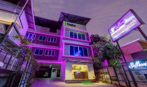 a pink building with a sign in front of it at Treebo Trend vSaffron Regency - Punnamada Lake in Alleppey