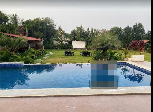 a large swimming pool in a yard with a house at Seascape Villa in Hyderabad