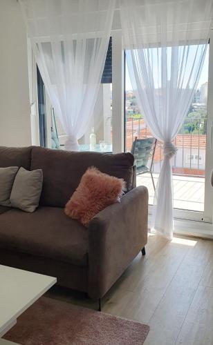 a brown couch in a living room with a window at Apartment Dino, Zadar in Zadar