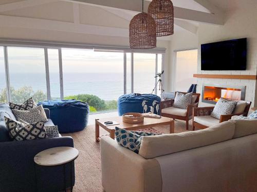 a living room with couches and a fireplace at Dolphin Dream in Herolds Bay