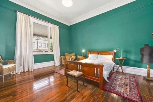 een slaapkamer met een bed en een blauwe muur bij Central Historic Gem in Launceston