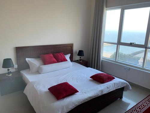 1 dormitorio con 2 camas y ventana grande en Family rooms with beach view, en Ajman