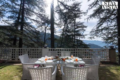 a table with plates of food sitting on top at StayVista at Oakwood Manor in Chhota Simla