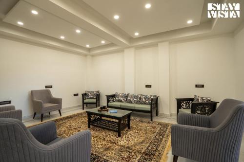 a waiting room with couches and chairs and a table at StayVista at Oakwood Manor in Chhota Simla