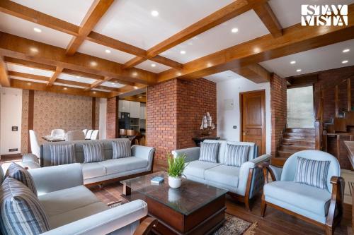a living room with couches and a table at StayVista at Oakwood Manor in Chhota Simla