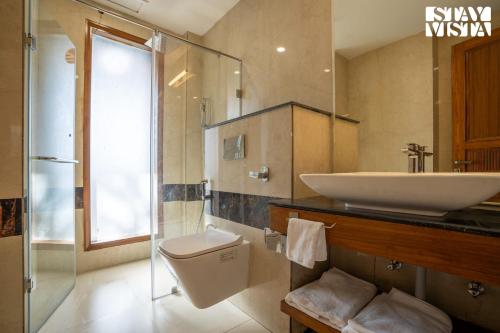 een badkamer met een wastafel en een toilet bij StayVista at Oakwood Manor in Chhota Simla