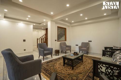 a living room with chairs and a table at StayVista at Oakwood Manor in Chhota Simla