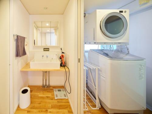 La salle de bains est pourvue d'un lavabo et d'un lave-linge. dans l'établissement Surf&Turf Aoshima - サーフ&ターフ青島 -, à Miyazaki