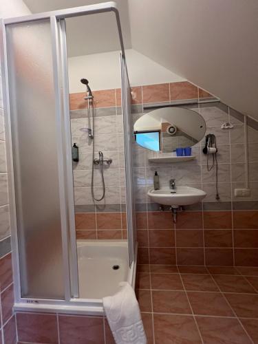 a bathroom with a shower and a sink at Butenas Hotel Tyla in Biržai