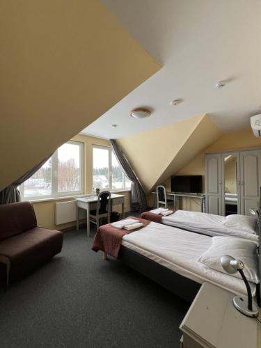 a bedroom with a large bed and a desk at Butenas Hotel Tyla in Biržai