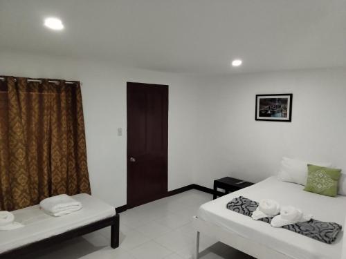 a room with two beds and a window at Moalboal Beach Front Hotel in Moalboal