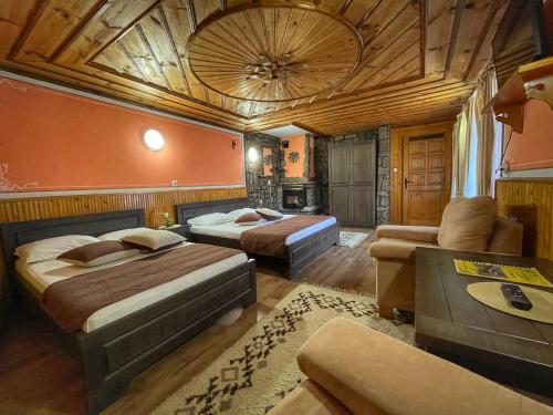 コプリフシティツァにあるGuest rooms Coloritのベッド2台とソファが備わるホテルルームです。