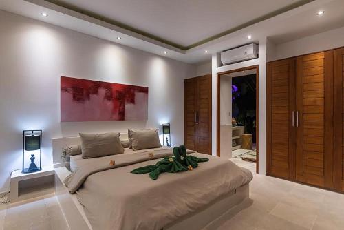 a bedroom with a large bed in a room at Villa Kallayaan by Optimum Bali Villas in Seminyak