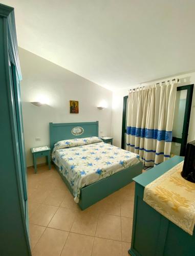1 dormitorio con 1 cama con edredón azul en Villetta a Tanaunella, en Tanaunella