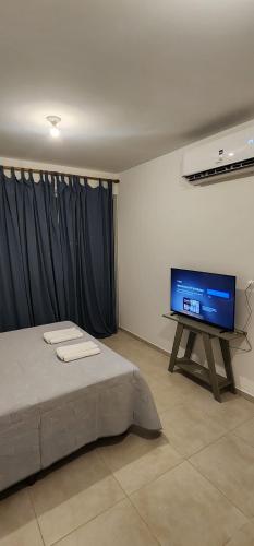 a bedroom with a bed and a flat screen tv at Departamento Studio con balcón en microcentro in Resistencia