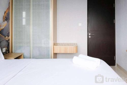 a bedroom with a white bed and a window at Apartement At Klaska Residence in Surabaya