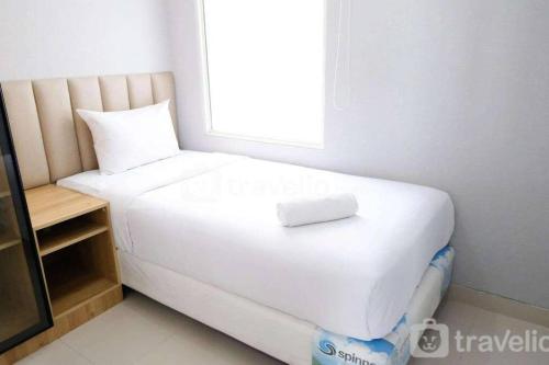 a white bed in a room with a window at Apartement At Klaska Residence in Surabaya