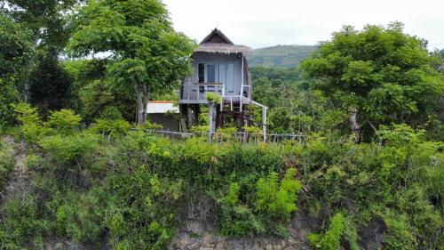 uma casa no topo de uma colina com árvores em Eco Tourist Dream Stay Tree House em Nusa Penida