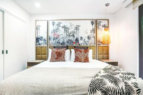 a bedroom with a large white bed with pillows at 235 Temple Tranquility Triton Retreat in Palm Cove