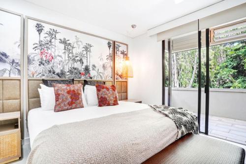 a bedroom with a bed and a large window at 235 Temple Tranquility Triton Retreat in Palm Cove