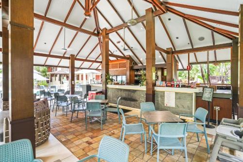 a restaurant with chairs and tables and a bar at 235 Temple Tranquility Triton Retreat in Palm Cove