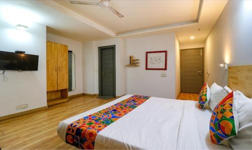 a bedroom with a large bed and a flat screen tv at FabHotel Majestic JPM I in New Delhi