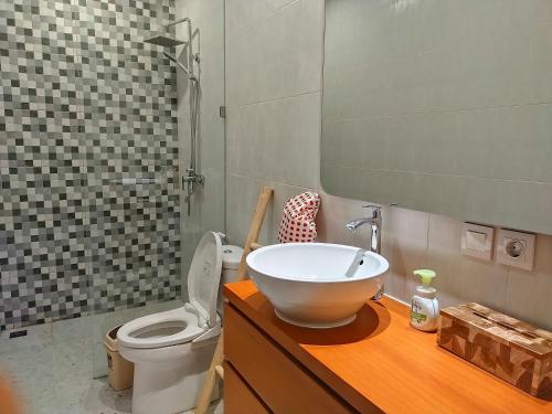 a bathroom with a bowl sink and a toilet at Capung Smart Residence in Sanur
