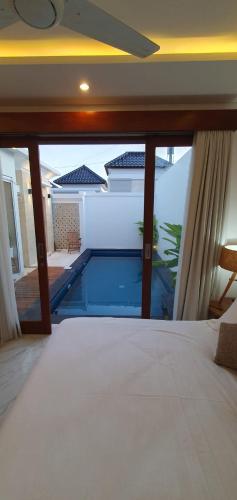 a bedroom with a view of a swimming pool at Capung Smart Residence in Sanur