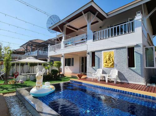 a house with a swimming pool in front of a house at Deluxe Pool Villa close to Beach and Walking Street! in Pattaya