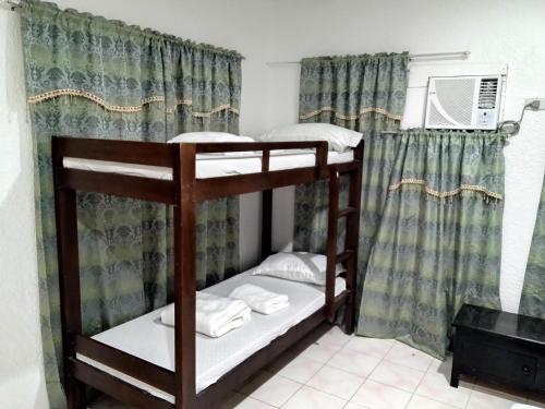 two bunk beds in a room with a window at Moalboal Beach Front Hotel in Moalboal