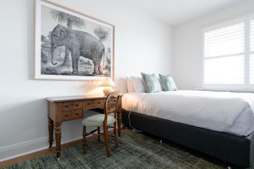 1 dormitorio con escritorio y una foto de elefante en la pared en Lovingly Restored Hampton's Haven, en Kings Park