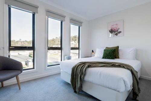 een witte slaapkamer met een bed en ramen bij Modern & Convenient in Newstead in Newstead