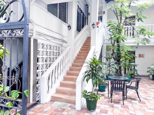 eine Treppe mit einem Tisch, Stühlen und Pflanzen in der Unterkunft SANTOS Pension House in Manila